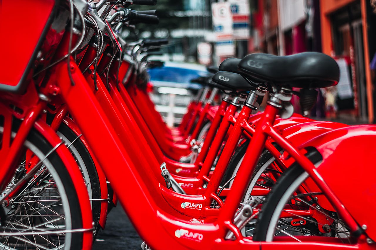ours-journey Rows of bright red bicycles parked in a bustling São Paulo street.