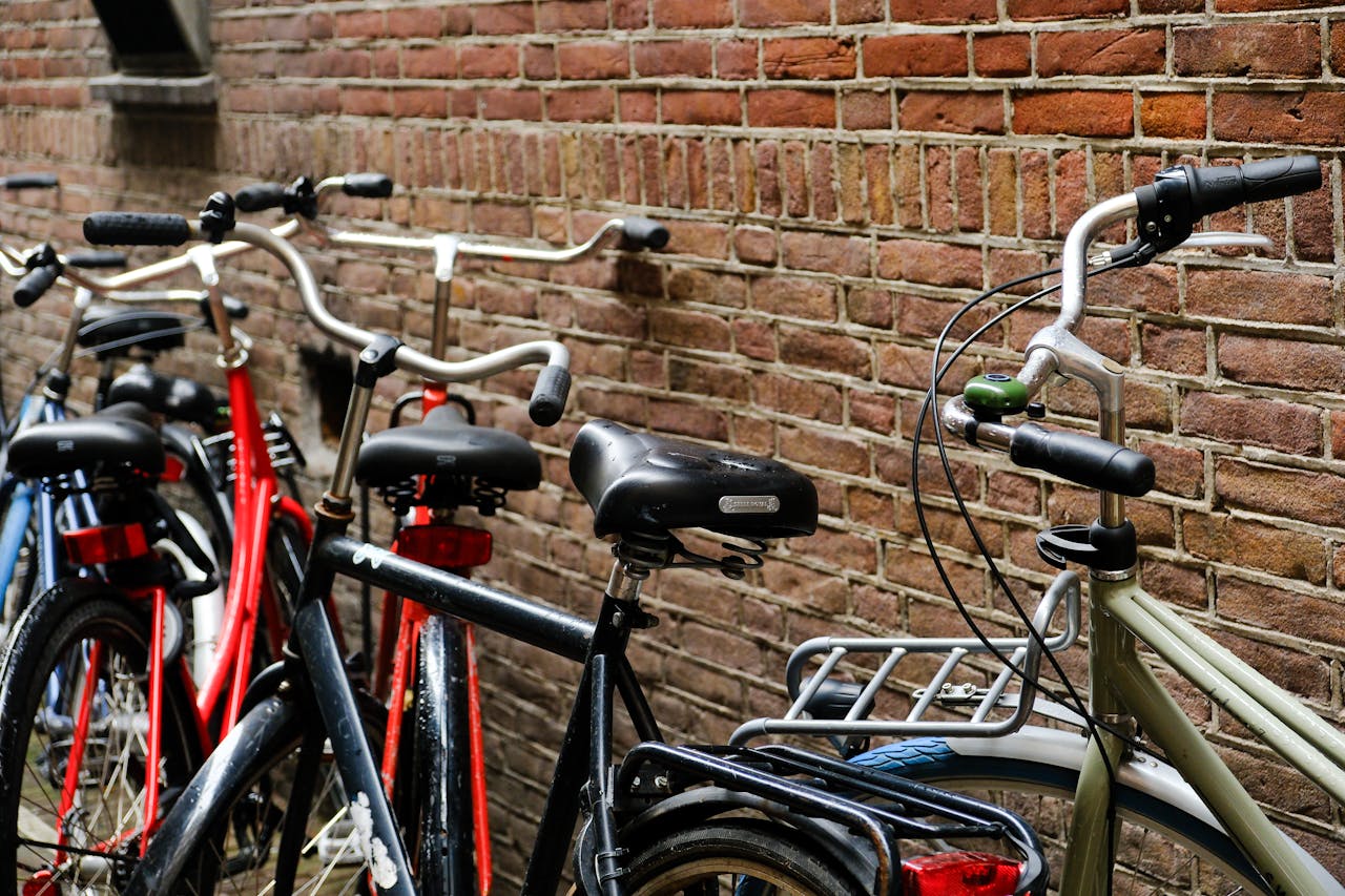 gallery-2 Bicycles parked against a classic brick wall, showcasing urban transport.