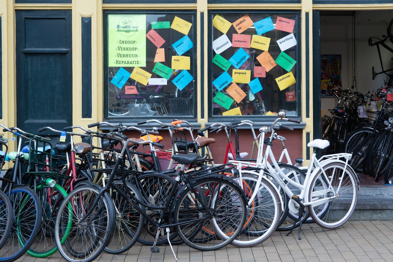 gallery-3 A bicycle shop exterior with various bikes and a colorful window display in an urban setting.