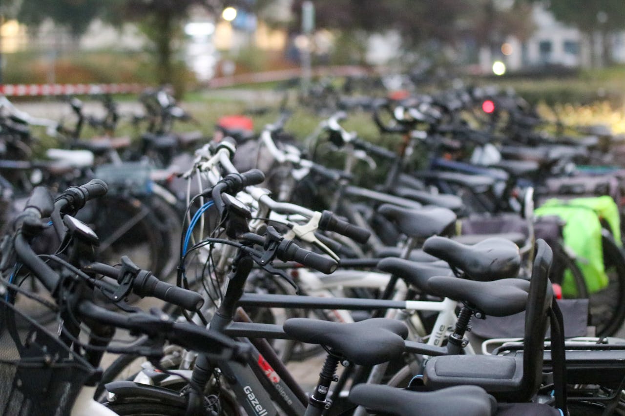 about-img A crowded bicycle parking area outdoors with various bikes parked in rows.