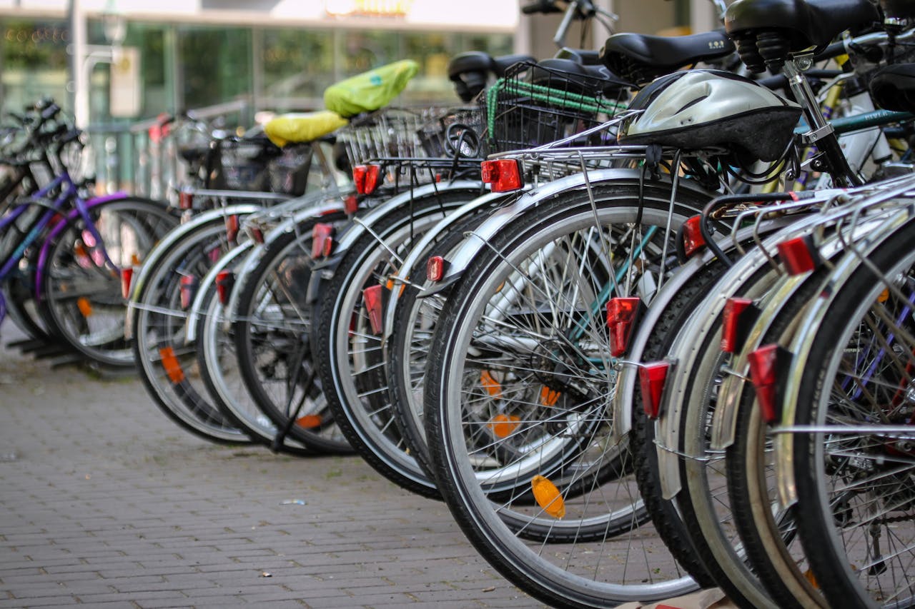 services-03 Multiple bicycles with helmets parked on a stone pavement. Ideal for urban transport themes.